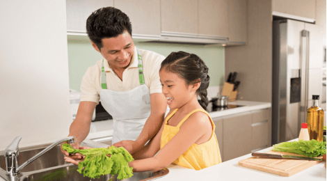 Father and daughter washing vegetables