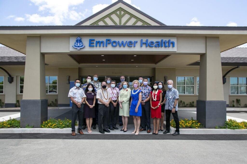 Staff with masks on standing in front of EmPower Health building