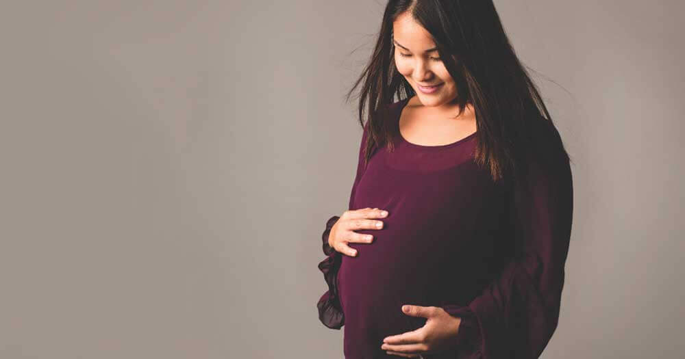 Pregnant woman caressing her belly.