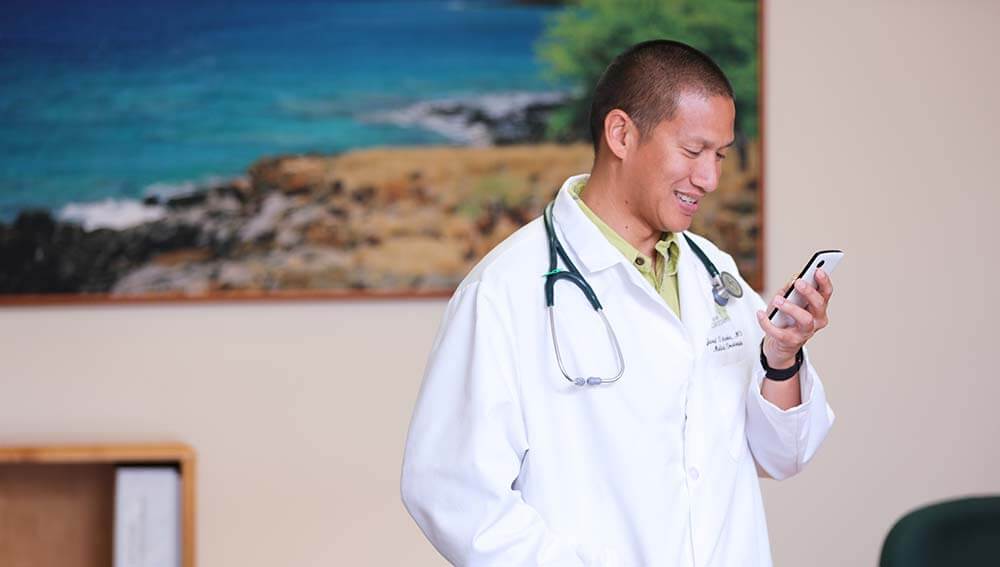 Male doctor speaks with patient on the phone.