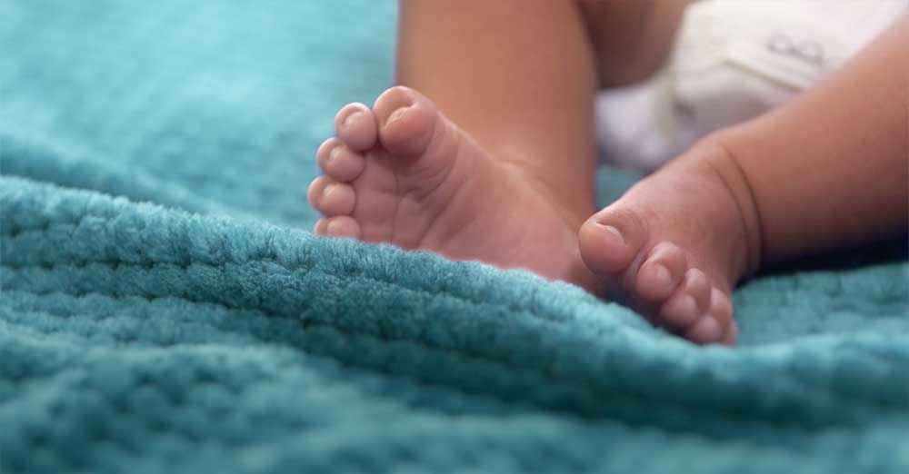 Close up of baby feet on a blue blanket