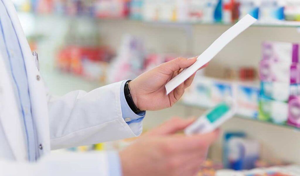 Pharmacist handing prescription medicine
