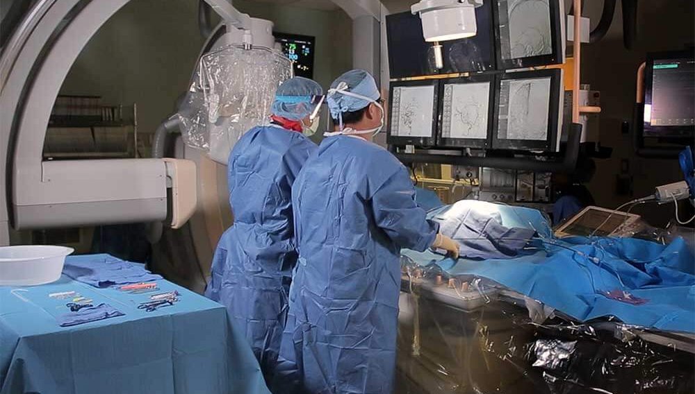 Neurologist looking at monitors while conducting a procedure in operating room.